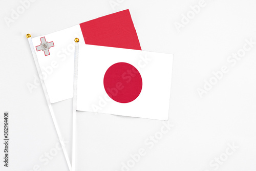 Free Download Japan and Malta stick flags on white background. High quality fabric, miniature national flag. Peaceful global concept.White floor for copy space. - GFXLoad