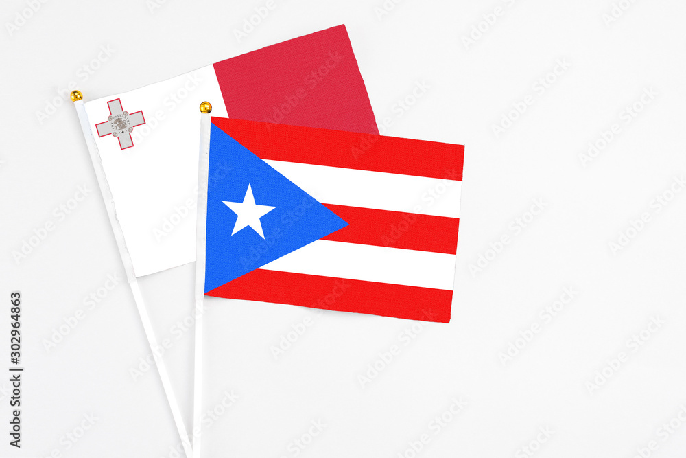 Puerto Rico and Malta stick flags on white background. High quality fabric, miniature national flag. Peaceful global concept.White floor for copy space. Puerto Rico and Malta stick flags on white background. High quality fabric, miniature national flag. Peaceful global concept.White floor for copy space.