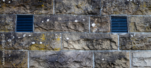 Old brick wall with two air vents