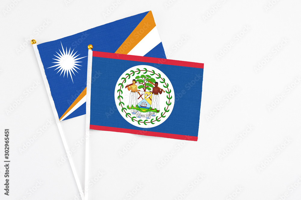 Belize and Marshall Islands stick flags on white background. High quality fabric, miniature national flag. Peaceful global concept.White floor for copy space. Belize and Marshall Islands stick flags on white background. High quality fabric, miniature national flag. Peaceful global concept.White floor for copy space.