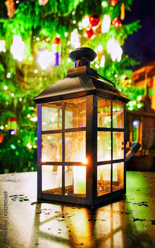 Glowing lantern with the candle at table on Christmas Market in Riga  Latvia. Europe in winter. German street Xmas and holiday fair. Advent Decoration and Stalls with Crafts Items on Bazaar
