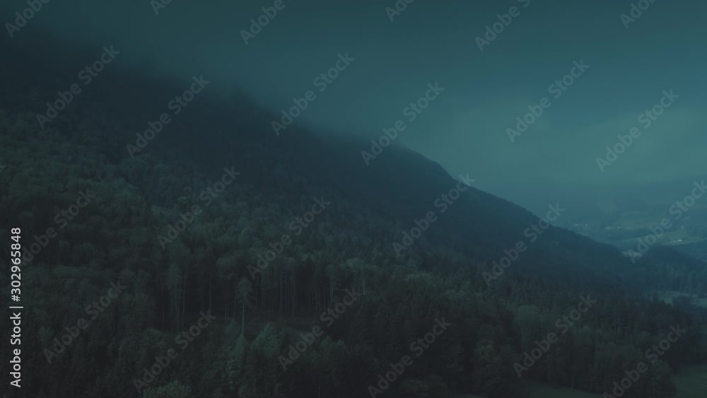 Moody night aerial flight over a mountain covered in dense forest and mist.
Moody night aerial flight over a mountain covered in dense forest and mist.