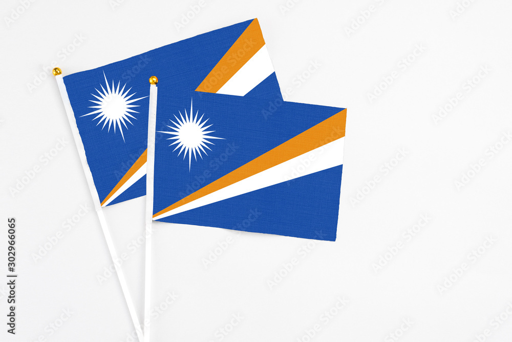 Marshall Islands and Marshall Islands stick flags on white background. High quality fabric, miniature national flag. Peaceful global concept.White floor for copy space. Marshall Islands and Marshall Islands stick flags on white background. High quality fabric, miniature national flag. Peaceful global concept.White floor for copy space.