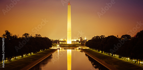 The Washington Monument at night with its image reflected in the National Mall reflecting pool. photo
