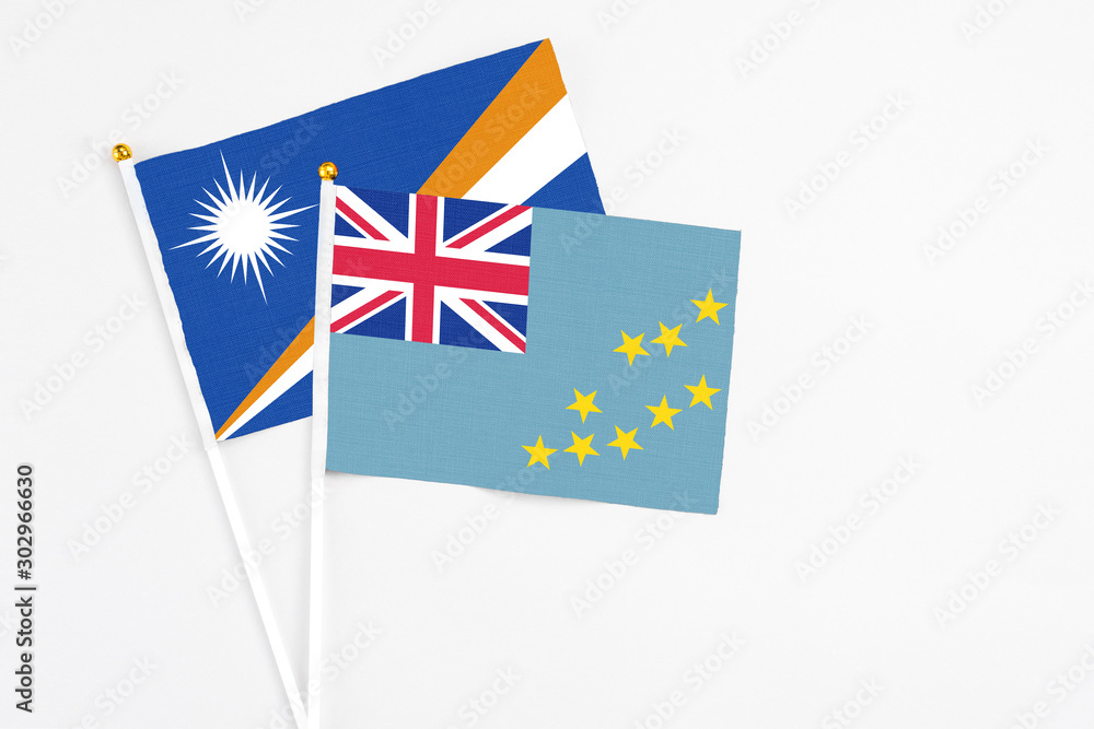 Tuvalu and Marshall Islands stick flags on white background. High quality fabric, miniature national flag. Peaceful global concept.White floor for copy space. Tuvalu and Marshall Islands stick flags on white background. High quality fabric, miniature national flag. Peaceful global concept.White floor for copy space.