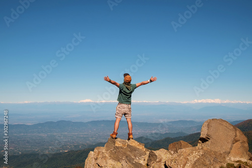 Young traveler standing on top of mountain with cliff
