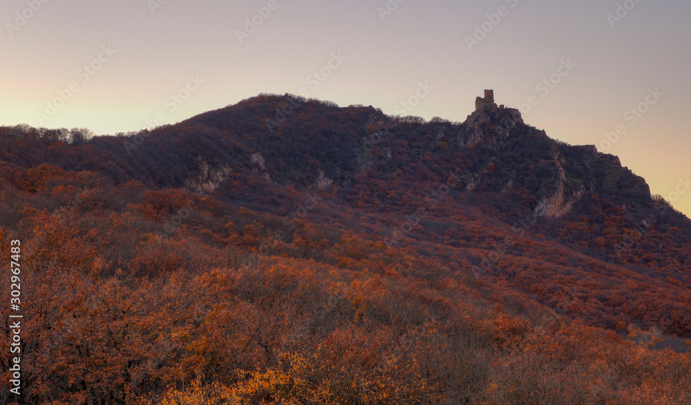 Ancient fortress on the mountain autumn slopes