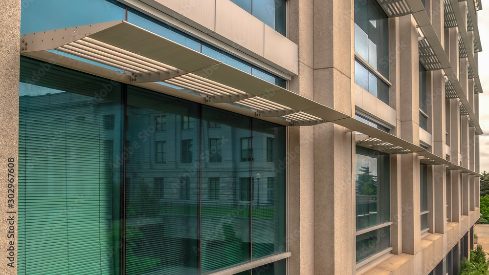 Panorama frame Office building exterior with close up on the glass windows and concrete wall Panorama frame Office building exterior with close up on the glass windows and concrete wall