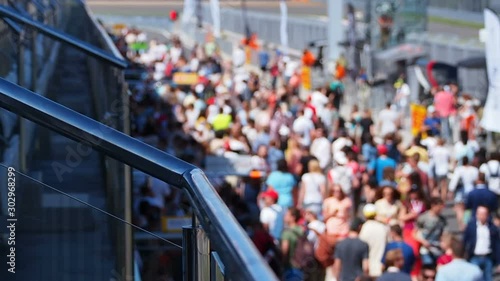 Blurred Out Crowd Walking on a Raceway Pitlane