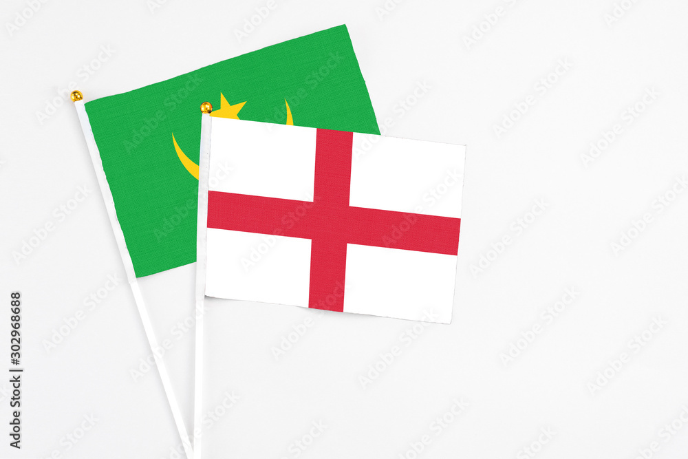 England and Mauritania stick flags on white background. High quality fabric, miniature national flag. Peaceful global concept.White floor for copy space.