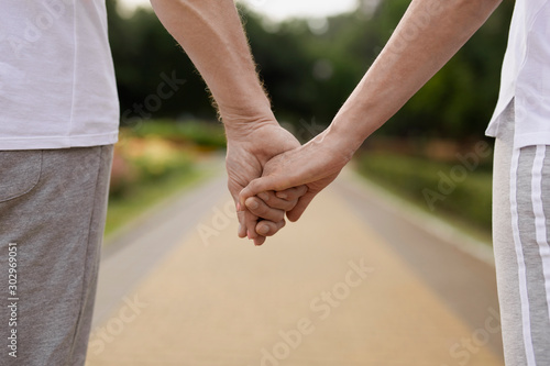 Romantic couple holding hands outdoors stock photo