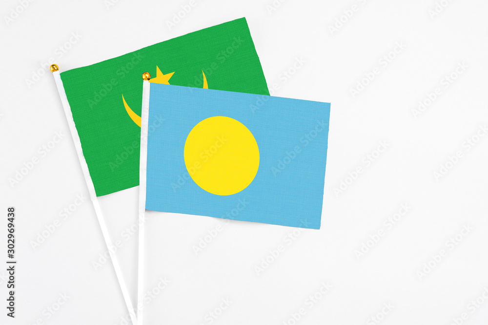 Palau and Mauritania stick flags on white background. High quality fabric, miniature national flag. Peaceful global concept.White floor for copy space. Palau and Mauritania stick flags on white background. High quality fabric, miniature national flag. Peaceful global concept.White floor for copy space.