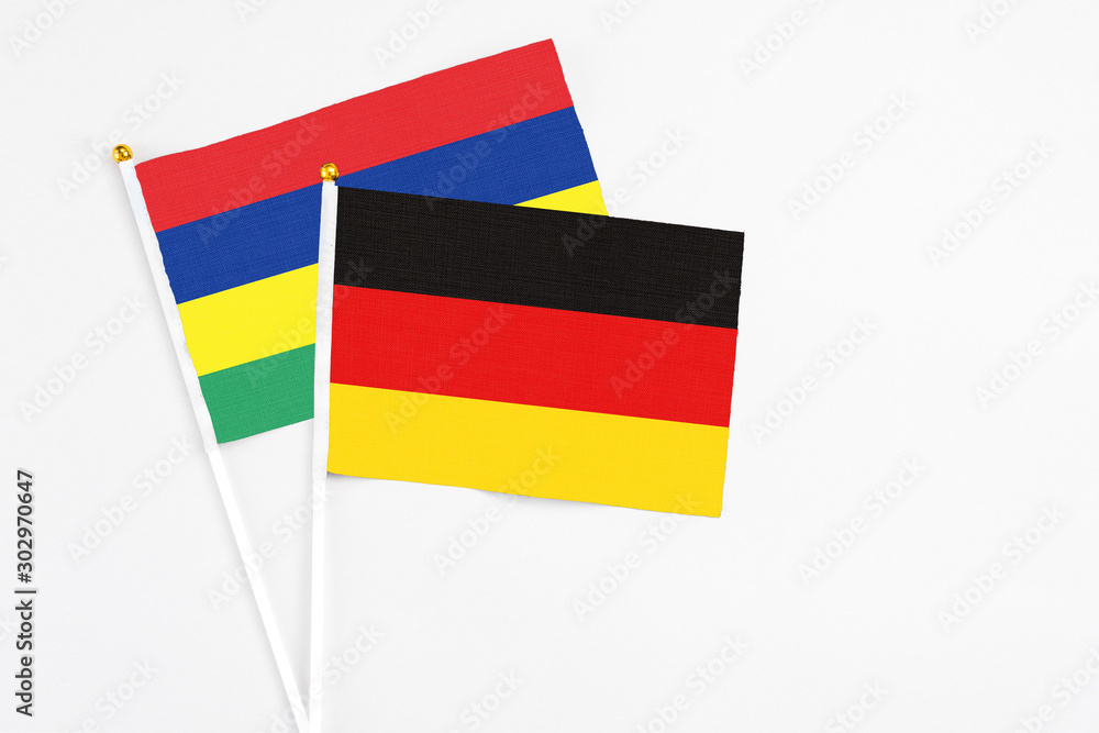 Germany and Mauritius stick flags on white background. High quality fabric, miniature national flag. Peaceful global concept.White floor for copy space. Germany and Mauritius stick flags on white background. High quality fabric, miniature national flag. Peaceful global concept.White floor for copy space.