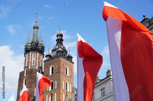 Polish red and white flags in the Old town in front of the building on a Sunny day.May 1, November 11, flag, independence or labor Day. Public holiday in Poland. decoration of the city with flags.