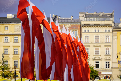 Polish red and white flags in the Old town in front of the building on a Sunny day.May 1, November 11, flag, independence or labor Day. Public holiday in Poland. decoration of the city with flags.