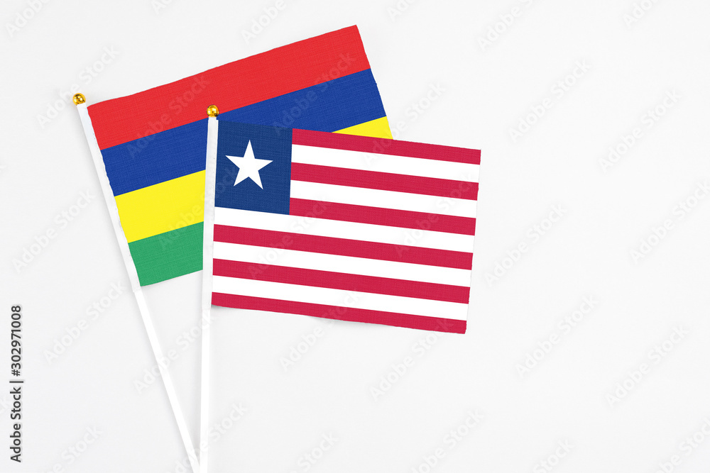 Liberia and Mauritius stick flags on white background. High quality fabric, miniature national flag. Peaceful global concept.White floor for copy space. Liberia and Mauritius stick flags on white background. High quality fabric, miniature national flag. Peaceful global concept.White floor for copy space.