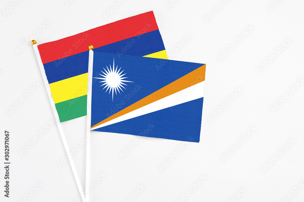 Marshall Islands and Mauritius stick flags on white background. High quality fabric, miniature national flag. Peaceful global concept.White floor for copy space. Marshall Islands and Mauritius stick flags on white background. High quality fabric, miniature national flag. Peaceful global concept.White floor for copy space.