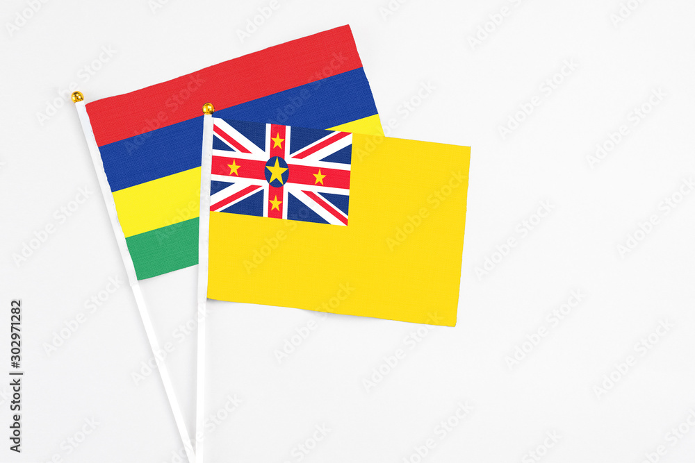 Niue and Mauritius stick flags on white background. High quality fabric, miniature national flag. Peaceful global concept.White floor for copy space. Niue and Mauritius stick flags on white background. High quality fabric, miniature national flag. Peaceful global concept.White floor for copy space.