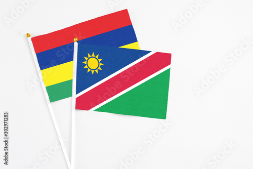 Namibia and Mauritius stick flags on white background. High quality fabric  miniature national flag. Peaceful global concept.White floor for copy space.