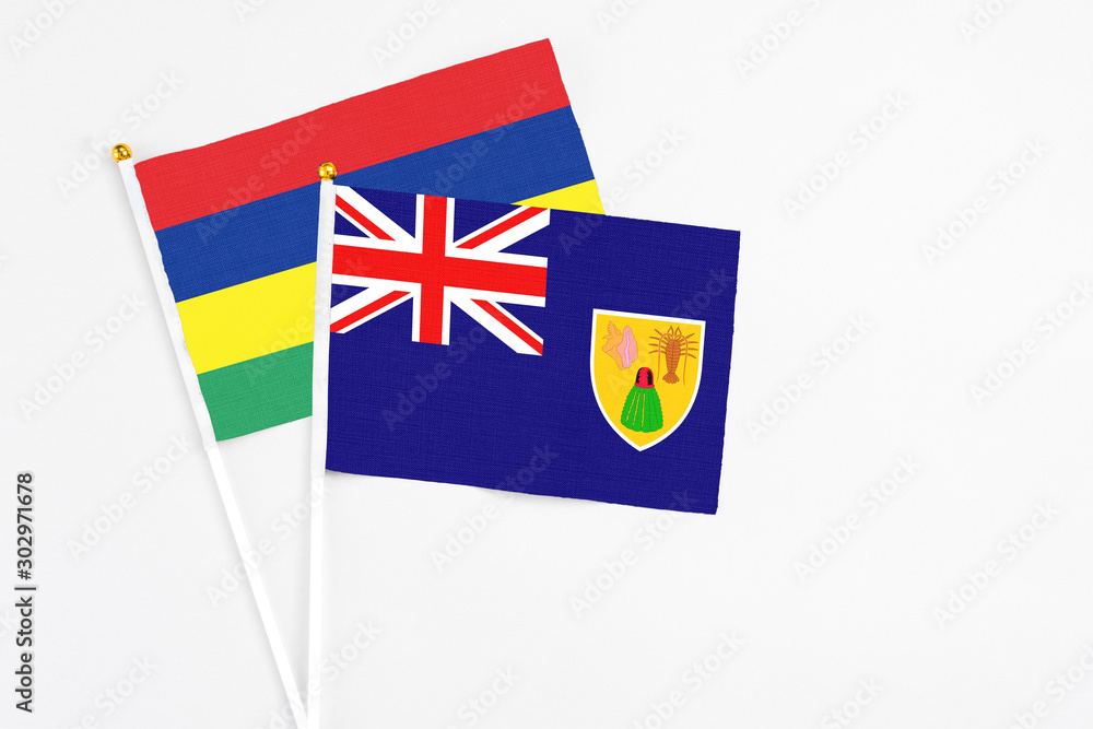 Turks And Caicos Islands and Mauritius stick flags on white background. High quality fabric, miniature national flag. Peaceful global concept.White floor for copy space. Turks And Caicos Islands and Mauritius stick flags on white background. High quality fabric, miniature national flag. Peaceful global concept.White floor for copy space.
