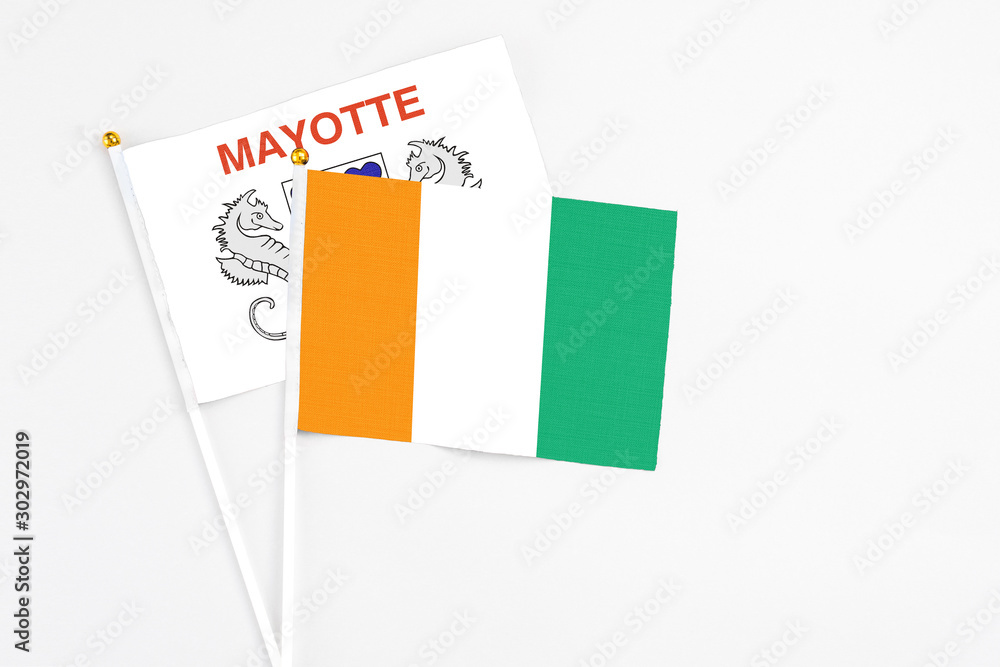 Cote D'Ivoire and Mayotte stick flags on white background. High quality fabric, miniature national flag. Peaceful global concept.White floor for copy space. Cote D'Ivoire and Mayotte stick flags on white background. High quality fabric, miniature national flag. Peaceful global concept.White floor for copy space.