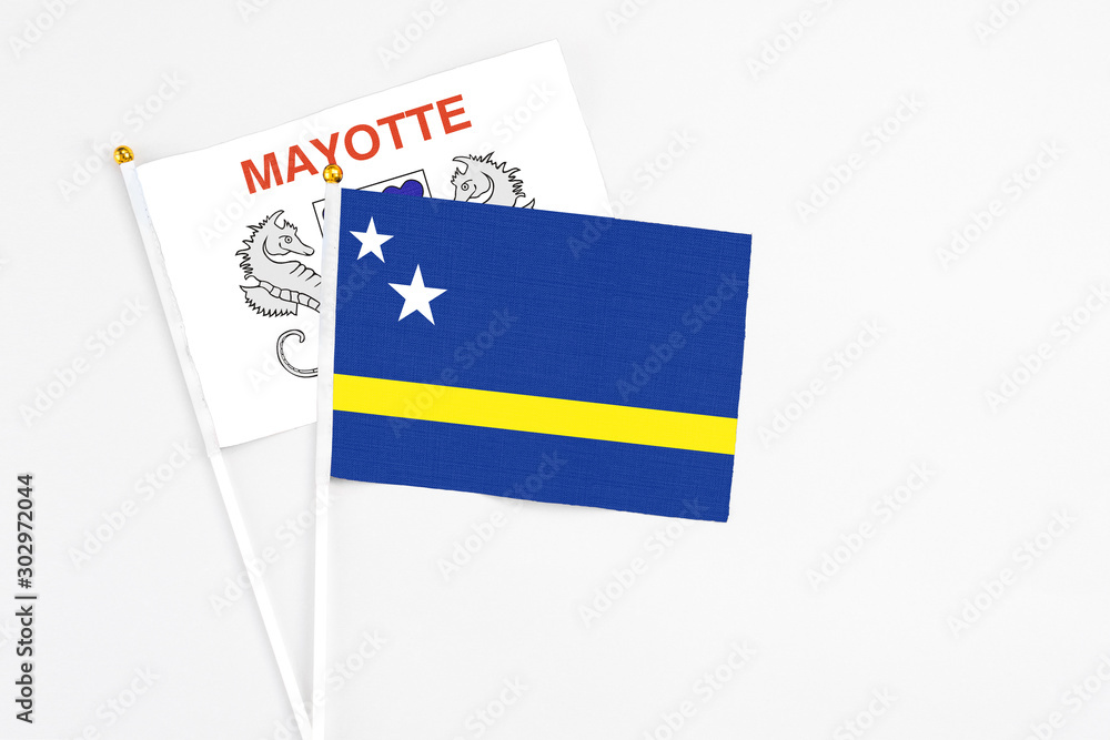Curacao and Mayotte stick flags on white background. High quality fabric, miniature national flag. Peaceful global concept.White floor for copy space. Curacao and Mayotte stick flags on white background. High quality fabric, miniature national flag. Peaceful global concept.White floor for copy space.