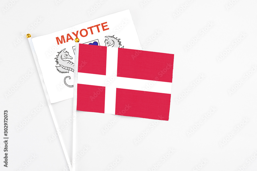 Denmark and Mayotte stick flags on white background. High quality fabric, miniature national flag. Peaceful global concept.White floor for copy space.