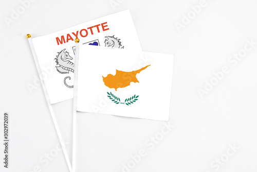 Cyprus and Mayotte stick flags on white background. High quality fabric, miniature national flag. Peaceful global concept.White floor for copy space.