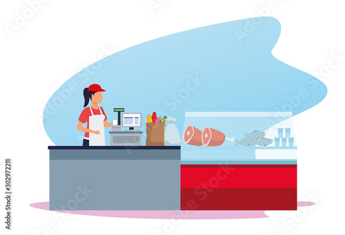 woman worker in supermarket cash register next to meat fridge