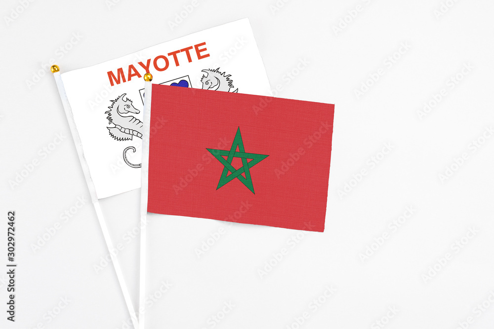 Morocco and Mayotte stick flags on white background. High quality fabric, miniature national flag. Peaceful global concept.White floor for copy space. Morocco and Mayotte stick flags on white background. High quality fabric, miniature national flag. Peaceful global concept.White floor for copy space.