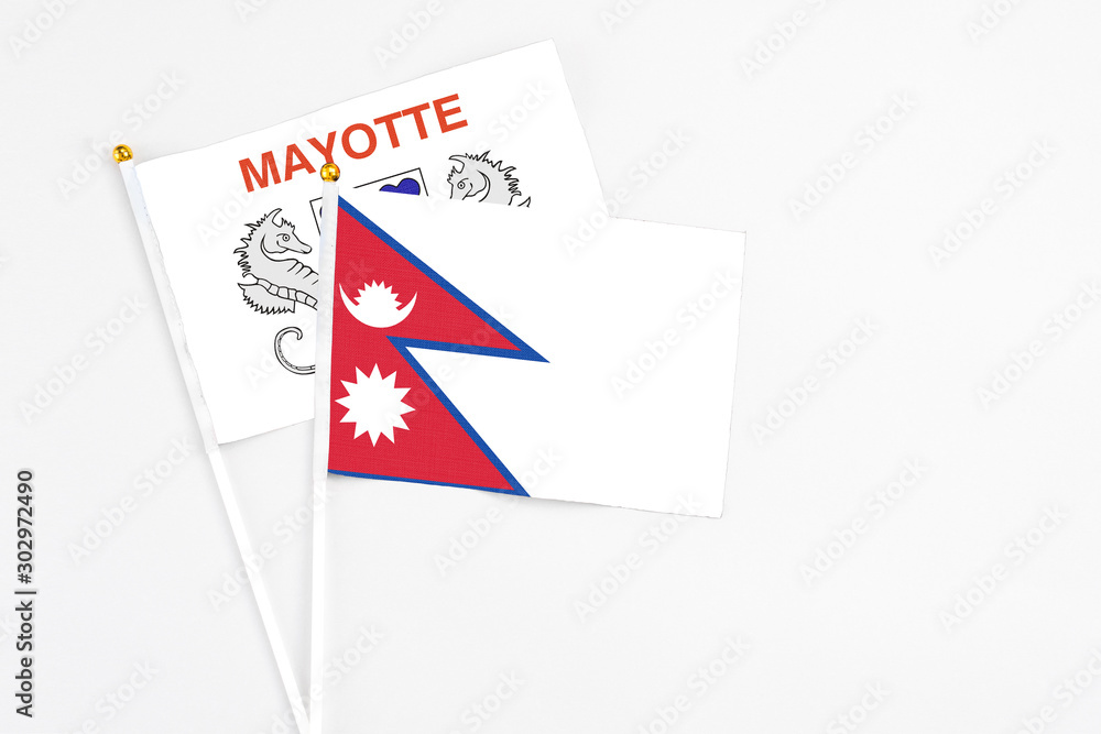 Nepal and Mayotte stick flags on white background. High quality fabric, miniature national flag. Peaceful global concept.White floor for copy space.