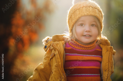 portrait of pretty little girl in yellow knitted hat and yellow coat