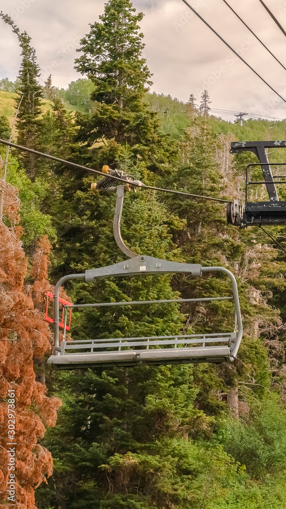 Vertical Chairlifts against vivid green trees and cloudy sky at Park City in off season Vertical Chairlifts against vivid green trees and cloudy sky at Park City in off season