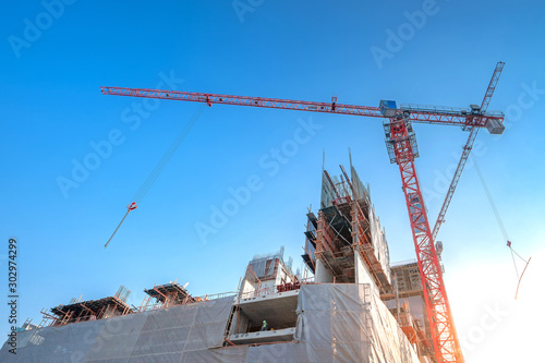 Workers are working on large construction sites and many cranes are working in the construction industry.