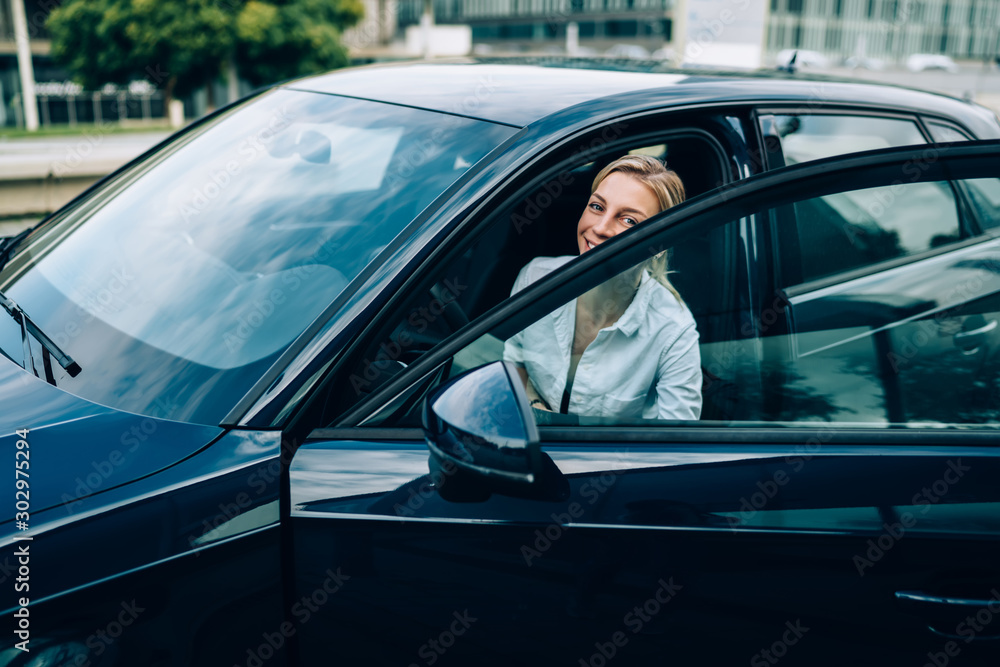 Blonde female peeping out from automobile