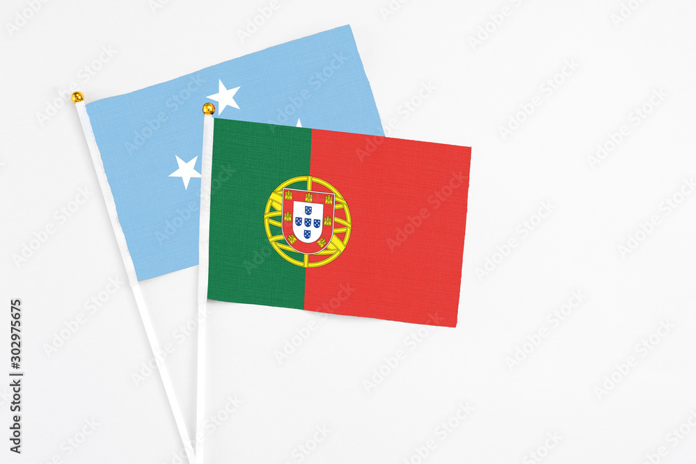 Portugal and Micronesia stick flags on white background. High quality fabric, miniature national flag. Peaceful global concept.White floor for copy space. Portugal and Micronesia stick flags on white background. High quality fabric, miniature national flag. Peaceful global concept.White floor for copy space.