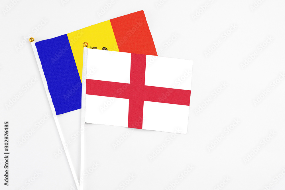 England and Moldova stick flags on white background. High quality fabric, miniature national flag. Peaceful global concept.White floor for copy space.