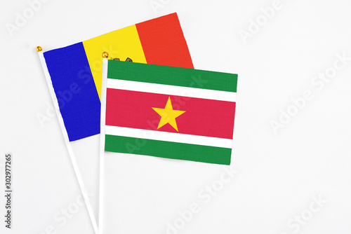 Suriname and Moldova stick flags on white background. High quality fabric, miniature national flag. Peaceful global concept.White floor for copy space.