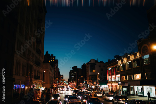Evening view of big city life with transport of roads during rush hour and lights in windows of commercial buildings, traffic jam in downtown district and modern constructed architecture real estate. © BullRun