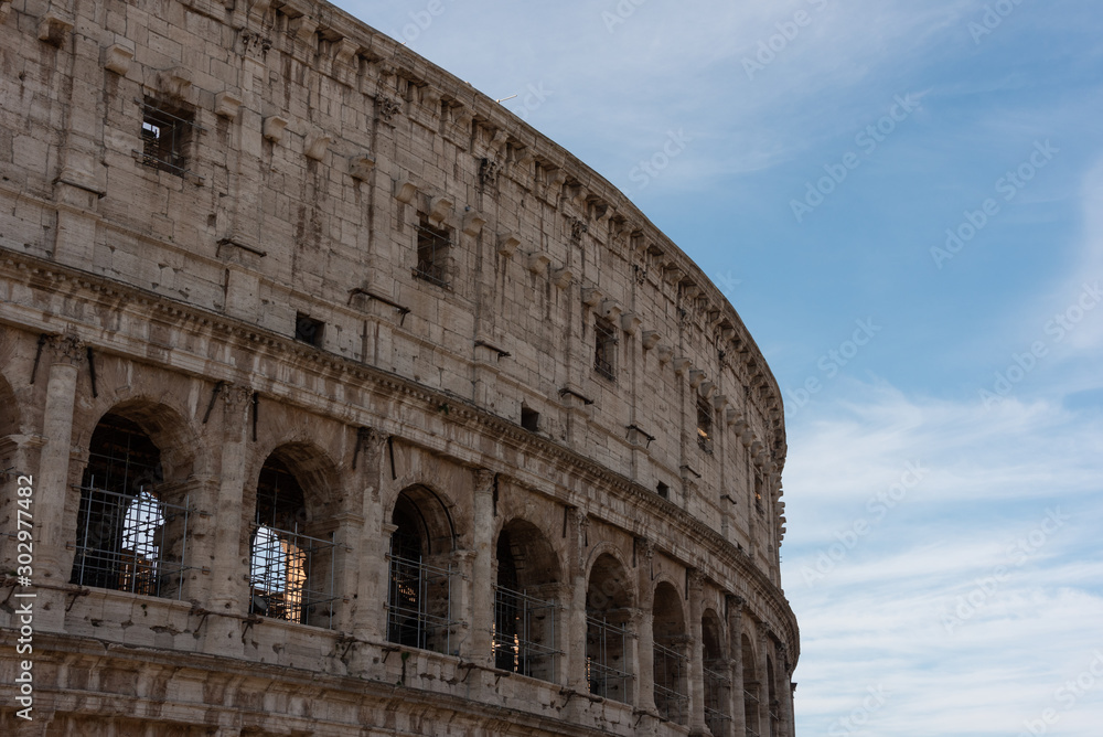 Part of the Colosseum in Rome, Italy with blue sky in the background. 