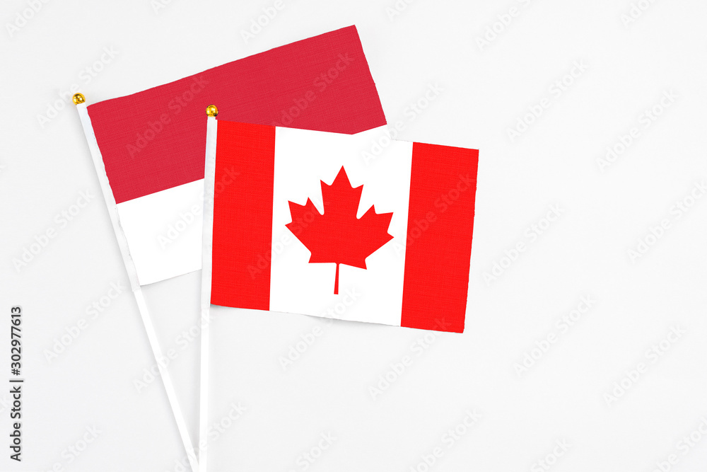 Canada and Monaco stick flags on white background. High quality fabric, miniature national flag. Peaceful global concept.White floor for copy space. Canada and Monaco stick flags on white background. High quality fabric, miniature national flag. Peaceful global concept.White floor for copy space.