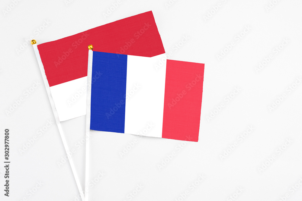 France and Monaco stick flags on white background. High quality fabric, miniature national flag. Peaceful global concept.White floor for copy space. France and Monaco stick flags on white background. High quality fabric, miniature national flag. Peaceful global concept.White floor for copy space.