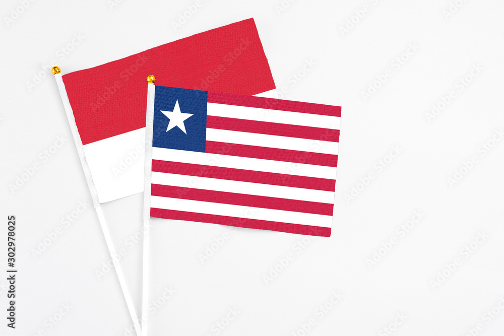 Liberia and Monaco stick flags on white background. High quality fabric, miniature national flag. Peaceful global concept.White floor for copy space. Liberia and Monaco stick flags on white background. High quality fabric, miniature national flag. Peaceful global concept.White floor for copy space.