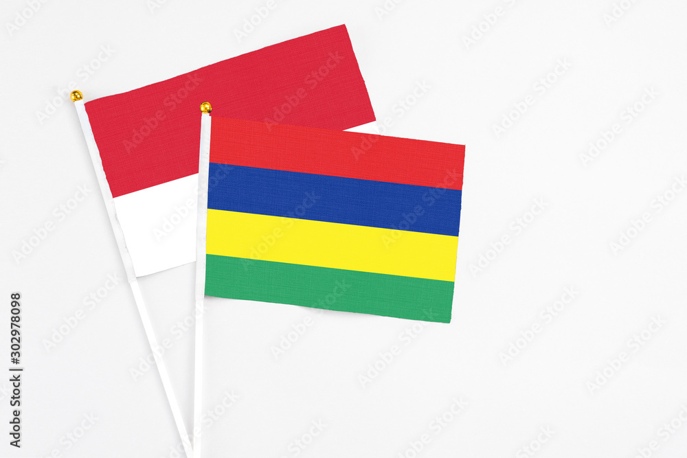 Mauritius and Monaco stick flags on white background. High quality fabric, miniature national flag. Peaceful global concept.White floor for copy space.