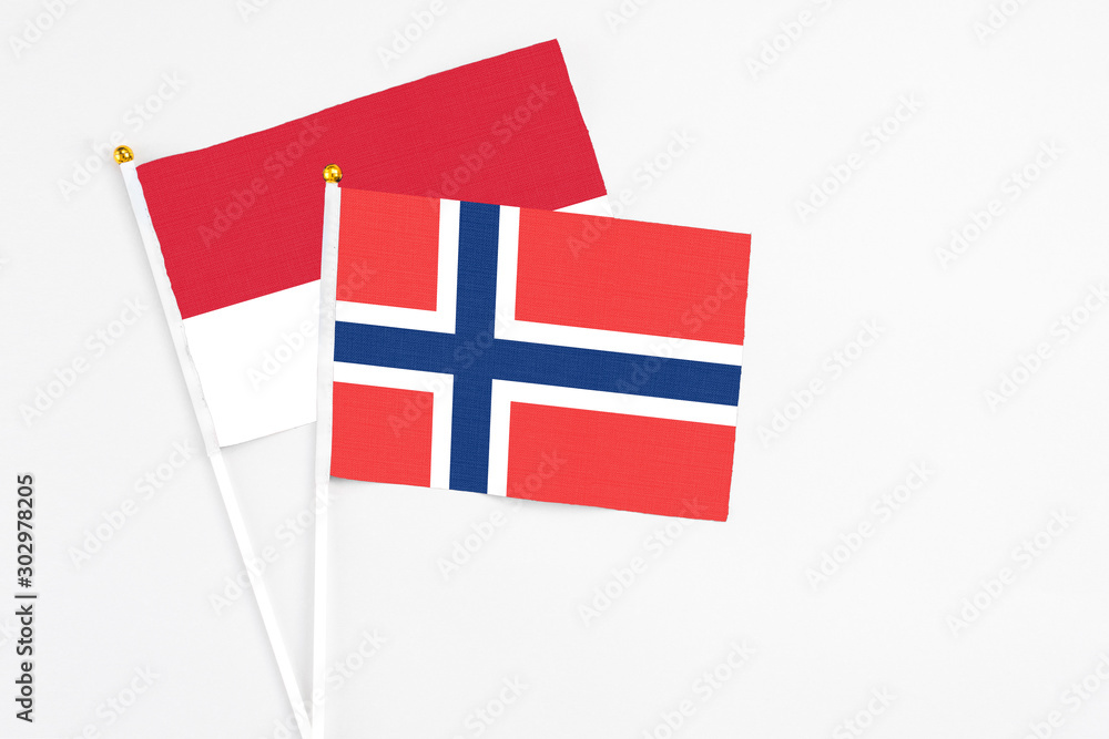 Norway and Monaco stick flags on white background. High quality fabric, miniature national flag. Peaceful global concept.White floor for copy space.