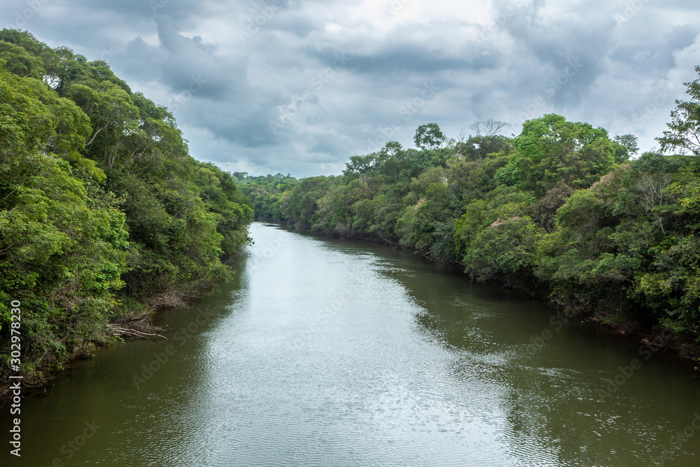 Beautiful view of Acara river with trees, rain and storm clouds in the Amazon rainforest, Concept of environment, global warming, climate change, ecology, biodiversity, conservation and travel.