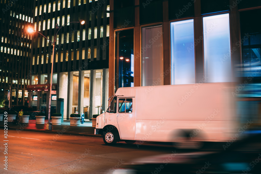 Van automobile driving on road in evening downtown transporting and distributing goods for delivery service, mock up copy space on cargo body for logistic company name or logo of startup business