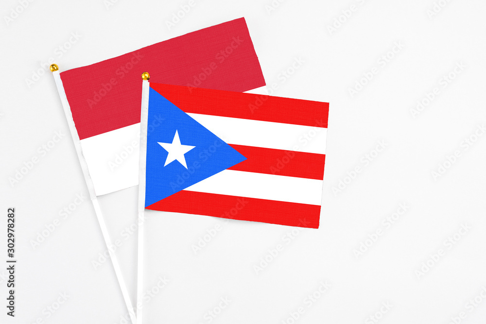 Puerto Rico and Monaco stick flags on white background. High quality fabric, miniature national flag. Peaceful global concept.White floor for copy space. Puerto Rico and Monaco stick flags on white background. High quality fabric, miniature national flag. Peaceful global concept.White floor for copy space.