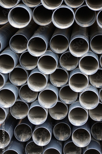gestapelte graue Wasserrohre auf einer Baustelle für die Wasserversorgung