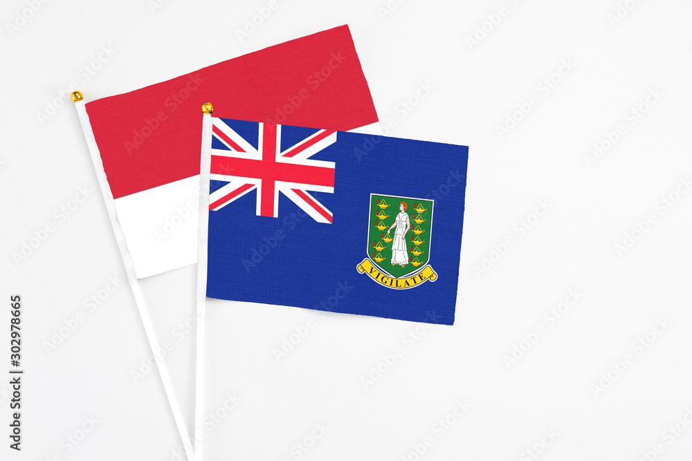 Fototapeta premium British Virgin Islands and Monaco stick flags on white background. High quality fabric, miniature national flag. Peaceful global concept.White floor for copy space.